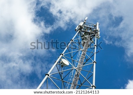 Bottom perspective pov of modern metal steel mobile 5g network wireless telecom tower against clear blue sky background on bright day. Microwave signal broadband equipment base line station mast Royalty-Free Stock Photo #2121264113