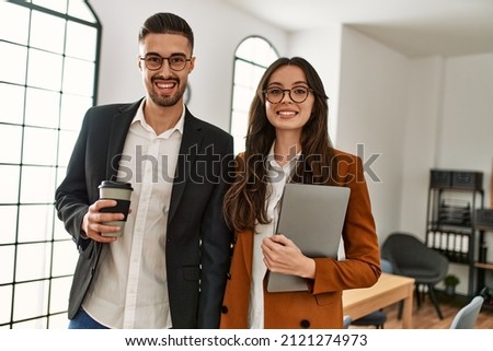 Two hispanic business workers smiling happy drinking coffee at the office. Royalty-Free Stock Photo #2121274973