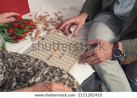 caucasian middle-aged man playing vocabulary games with his elderly mother durimong Mother's Day. High quality photo