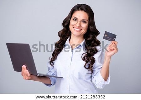 Photo of confident banker lady hold netbook debit card wear glasses blue shirt isolated grey color background