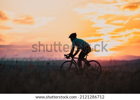 cyclist silhouette at sunset sports and fitness concept Royalty-Free Stock Photo #2121286712