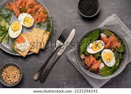 Food photography of salad, boiled eggs, salmon, crackers Royalty-Free Stock Photo #2121296141