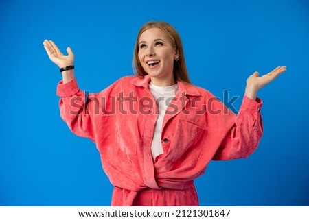 Excited thrilled woman portrait on blue studio background
