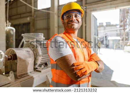 Worker with safety equipment working at construction plant Royalty-Free Stock Photo #2121313232