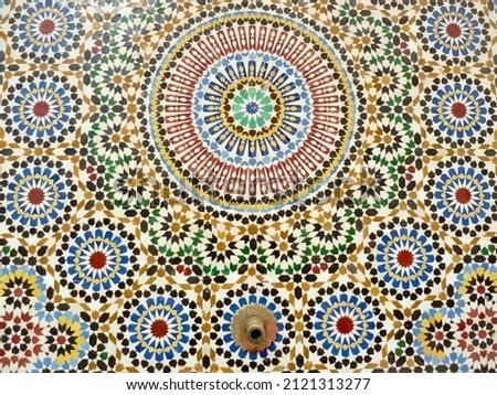 Close up traditional fountain, colorful glazes ceramic wall tiles in Islamic design. Rabat, Morocco. High quality photo