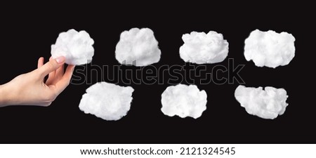Cotton clouds set isolated on black background. Hand holding white cloud. Surrealism style. High quality photo Royalty-Free Stock Photo #2121324545