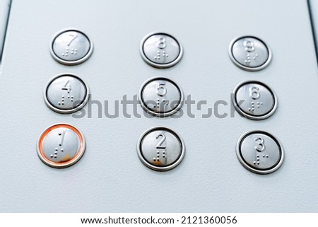 A close shot of burning elevator buttons. First floor. Call the elevator cabin. Minimalistic design of buttons. High quality photo