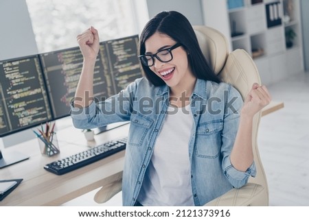 Photo of excited skilled lady editor sit desk fist up celebrate error solving server improving in workplace