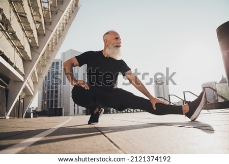 Photo of flexible endurant confident pensioner coach show stretching pose wear t-shirt urban town outdoors