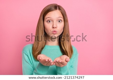 Photo of pretty cute schoolgirl wear turquoise sweater sending arms kiss isolated pink color background