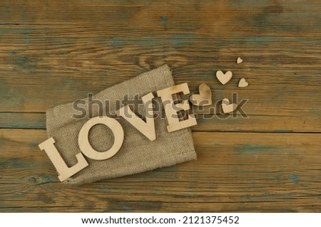 Love word, small hearts on dold woodr background. Top view of Valentine's Day. Copyspace.