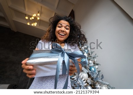 Woman gives a gift to his friend in the camera.
