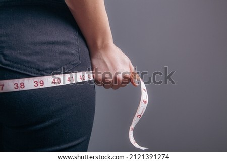 A woman measures the pee with a centimeter tape.