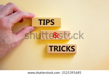 Tips and tricks symbol. Concept words Tips and tricks on wooden blocks. Beautiful white table white background. Businessman hand. Business, tips and tricks concept. Copy space.