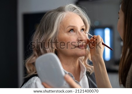 Elderly woman doing make-up in a beauty salon Royalty-Free Stock Photo #2121400070