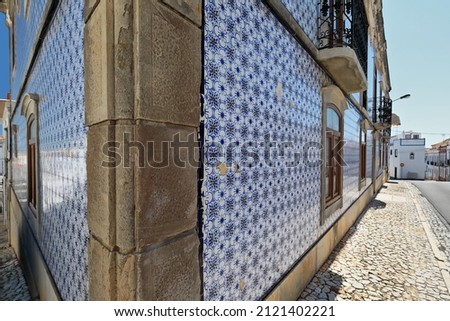 Tiled facade of Portuguese azulejo-floral and geometric motifs-traditional blue and white colors-townhouse on the corner of R.do Salto and R.Alvares Botelho Streets junction. Tavira-Algarve-Portugal.
