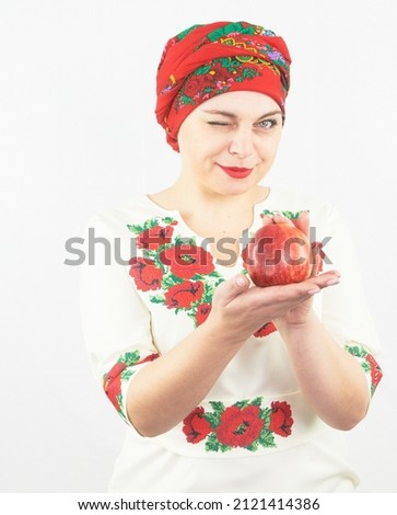 Beautiful ukrainian woman on traditional Ukrainian national clothes holds apple isolated on white background