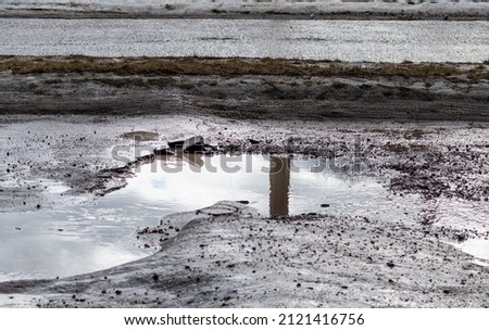 Dangerous huge potholes filled with dirty water on city road Royalty-Free Stock Photo #2121416756