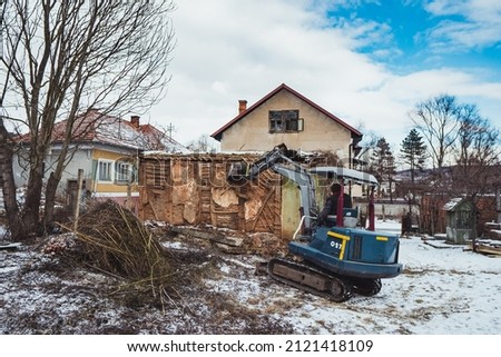 Old house being demolished by a digger.