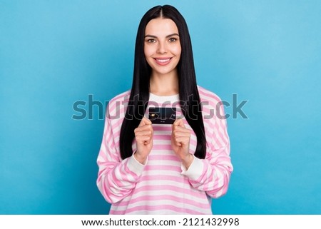 Photo of young cheerful girl hold bank card benefit profit earnings isolated over blue color background