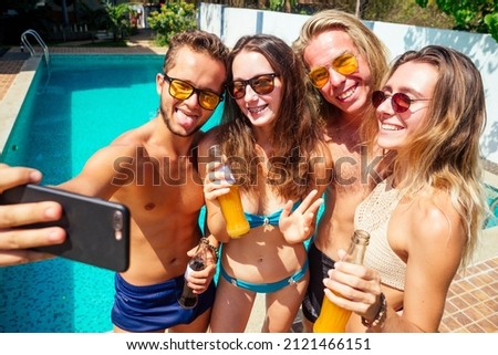 attractive six friends making self portrait on smartphone in swimmingpool