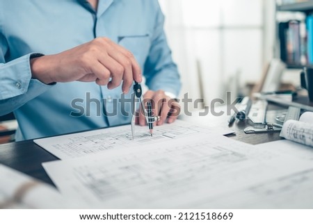 Architect engineer use compass drawing design working on blueprint. House planning design and construction concept.