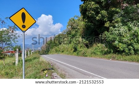 Takengon, Aceh, Indonesia –January 29, 2022: Warning road sign with exclamation mark with mountains wallpaper
