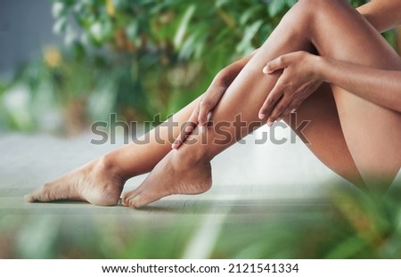 Your legs need some loving too. Cropped shot of an unrecognizable woman touching her legs. Royalty-Free Stock Photo #2121541334