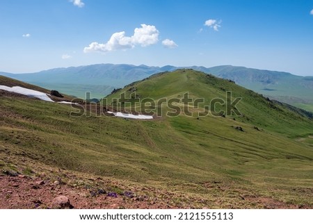 Beautiful mountains with cloudy sky on background. Kyzyl-auz mountain pass connecting Assy plateau and Zhenishke river valley. Tourism, travel in Kazakhstan concept. Spring season. Nature background.