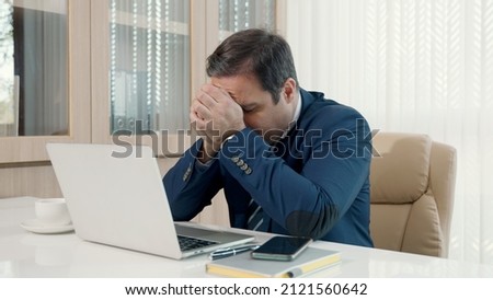 Stressed businessman feeling sick and tired while sitting at his working place, Angry and frustrated strain, businessman overworked upset with laptop unhappy and fail his work Royalty-Free Stock Photo #2121560642