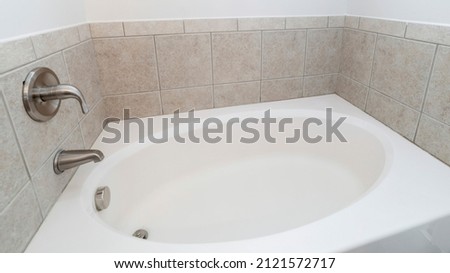 Panorama Alcove bathtub with gray tiles surround and wall mounted stainless faucet fixtures Royalty-Free Stock Photo #2121572717