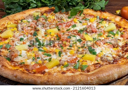 Pizza with bacon and cheese, herbs and cherry tomatoes. With mozzarella, shrimps and octopuses, mussels and other products on a wooden background. copy space.
