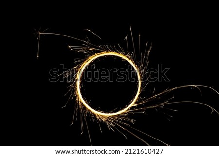 Circular lights with sparks on a black background Royalty-Free Stock Photo #2121610427