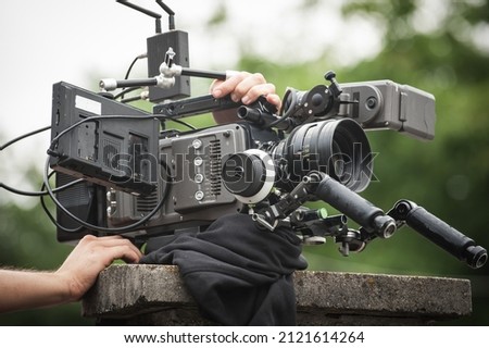 Behind the scene. Cameraman shooting the film scene with his camera on outdoor location