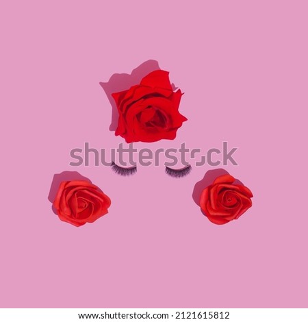 Abstract female face with false eyelashes and red roses hair. Love and make up concept flat lay.
Feminine beauty minimal concept. 