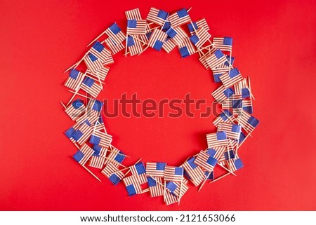 American flags flat lay in round frame on the red background with copy space. Happy Independence day USA.