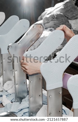 Hosiery factory. Mass production of clothing. Stacking and laying socks. Socks in different colors and sizes. Tights, leggings, stockings, stockings. Underwear. Textile products. Hand layout. 