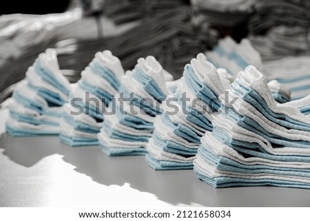 Hosiery factory. Mass production of clothing. Stacking and laying socks. Socks in different colors and sizes. Tights, leggings, stockings, stockings. Underwear. Textile products. Hand layout.  Royalty-Free Stock Photo #2121658034