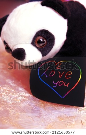 Note I love you for Valentines Day with cute panda toy. Art scratch paper for message