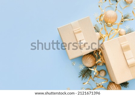 Composition with Christmas gift boxes, balls and fir branches on blue background