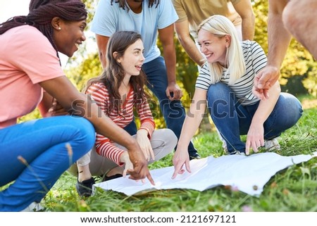 Group of young people doing geocaching as a scavenger hunt for teamwork and cooperation Royalty-Free Stock Photo #2121697121