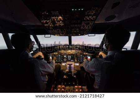 back view of professionals piloting modern airplane Royalty-Free Stock Photo #2121718427