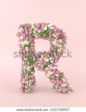 Creative letter R concept made of fresh Spring wedding flowers. Flower font concept on pastel pink background.