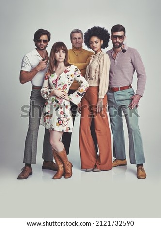 Nothing like some 70s style. A studio shot of a group of people standing together while clad in retro 70s wear. Royalty-Free Stock Photo #2121732590