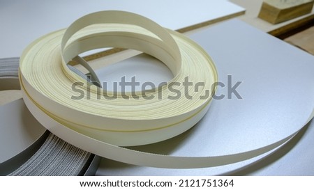 Roll melamine edge for finishing of furniture, hand made furniture production, selective focus Royalty-Free Stock Photo #2121751364