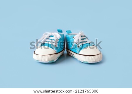 Baby's little blue sneakers on a colorful background. The concept of waiting for a baby and the concept of traveling with baby, children's lifestyle. Copy space, flat lay Royalty-Free Stock Photo #2121765308
