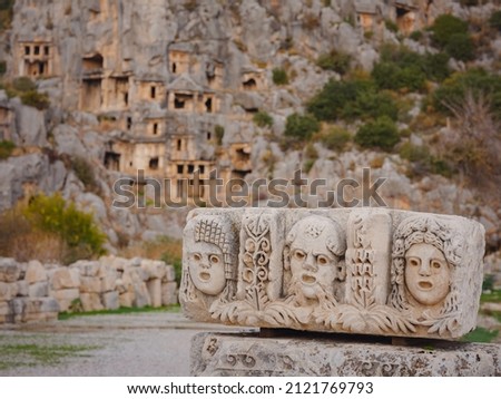 Archeological remains of the Lycian rock cut tombs in Myra, city Demre in Turkey. old stone masks used in theater actors in the rock tombs