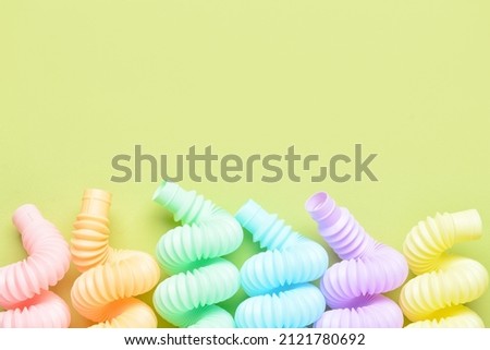 Different colorful Pop Tubes on green background