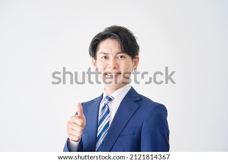 Asian businessman thumbs up gesture in white