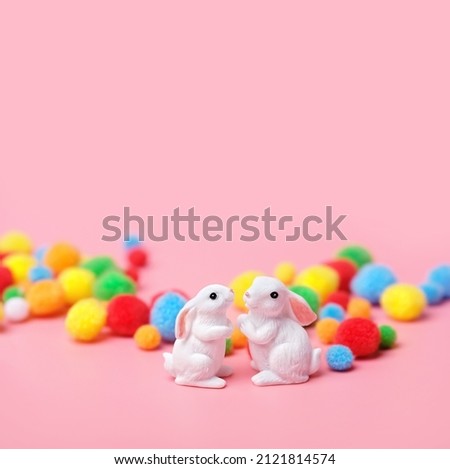 two cute white rabbits and colorful balls on abstract pink background. Easter bunnies toys. minimal composition, creative concept. Copy space	